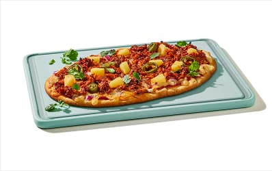 Flatbread pizza topped with al pastor pulled pork, pineapple, jalapenos, red onion and cilantro.