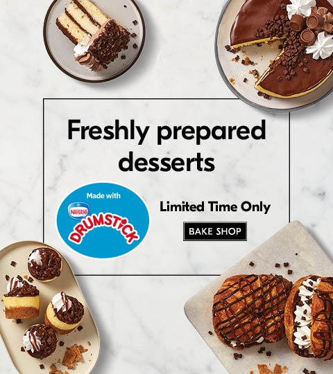 Selection of NESTLÃƒâ€° DRUMSTICK infused desserts ranging from a cake, cake slices and croissants on white plates, sitting on a neutral, marbled background.
