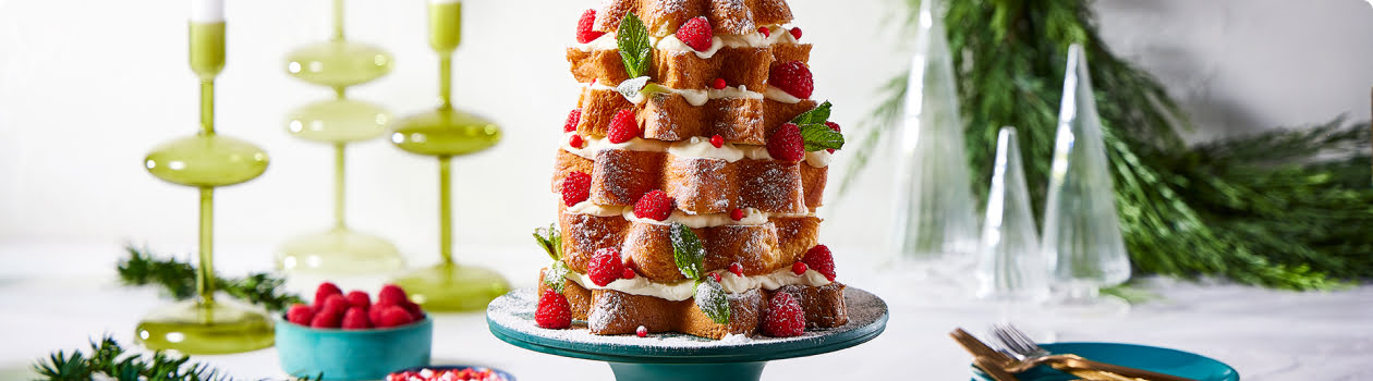 Pannatone bread stacked to look like a Christmas tree lightly dusted with icing sugar