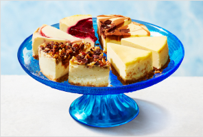 Slices of assorted cheesecake plated on a cake stand.