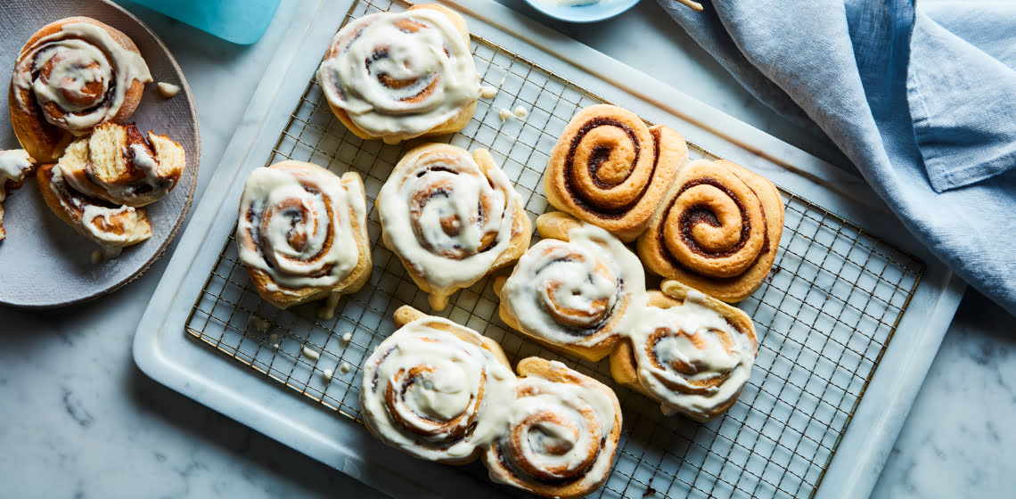 Marble surface with cooling rack of glazed cinnamon rolls