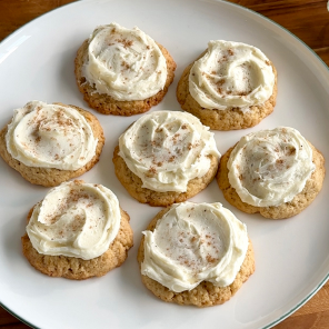 Frosted eggnog spiced cookies on a white plate