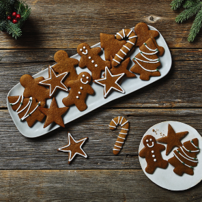 Assortment of gingerbread cookies on white plates on a wooden background