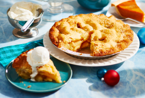 Pumpkin pie on tray with slice cut out.