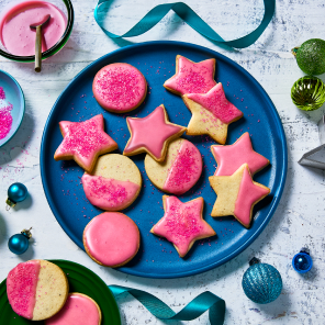 An overhead shot of ornament cookies in star and circle shapes with a pomegranate glaze