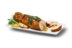 Apple Stuffed Pork Tenderloin on plate with sage and apples on side.