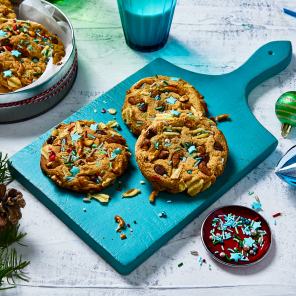 A few Santa trash cookies on a board and a few in a cookie tin