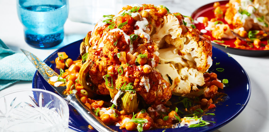 Close-up of whole roasted cauliflower in blue dish