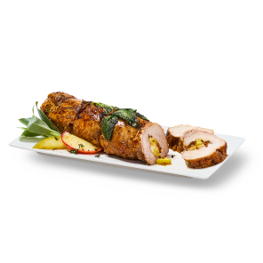 Pork tenderloin stuffed with apples and caramelized onions on a plate with two pieces cut off, sage leaves and apple slices