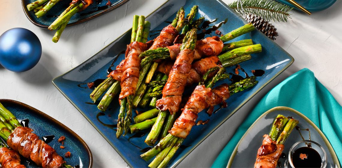 Bacon-wrapped asparagus on a blue rectangular plate