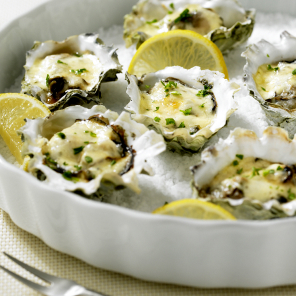 Close-up of oysters served on ice with lemon wedges and herbs