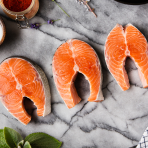 Three raw salmon steaks on a counter