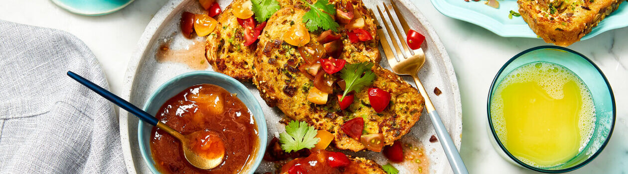 Savoury French toast slices on a beige plate topped with fresh cherry tomato salsa.