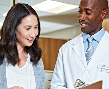 Pharmacist and customer reviewing notes