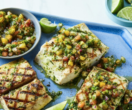 Blue platter of grilled mahi mahi filets with homemade summer herb sauce