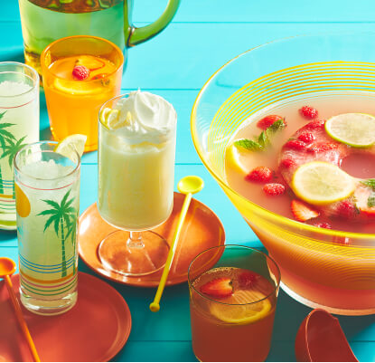 aqua blue wooden table top with yellow tray, holding glasses of iced lemonade, whipped lemonade, and and lemonade punch