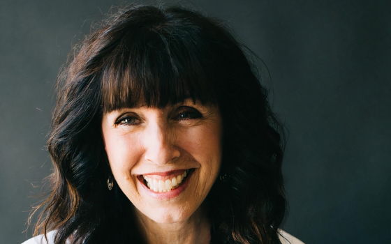 A brunette woman in a white dress shirt.